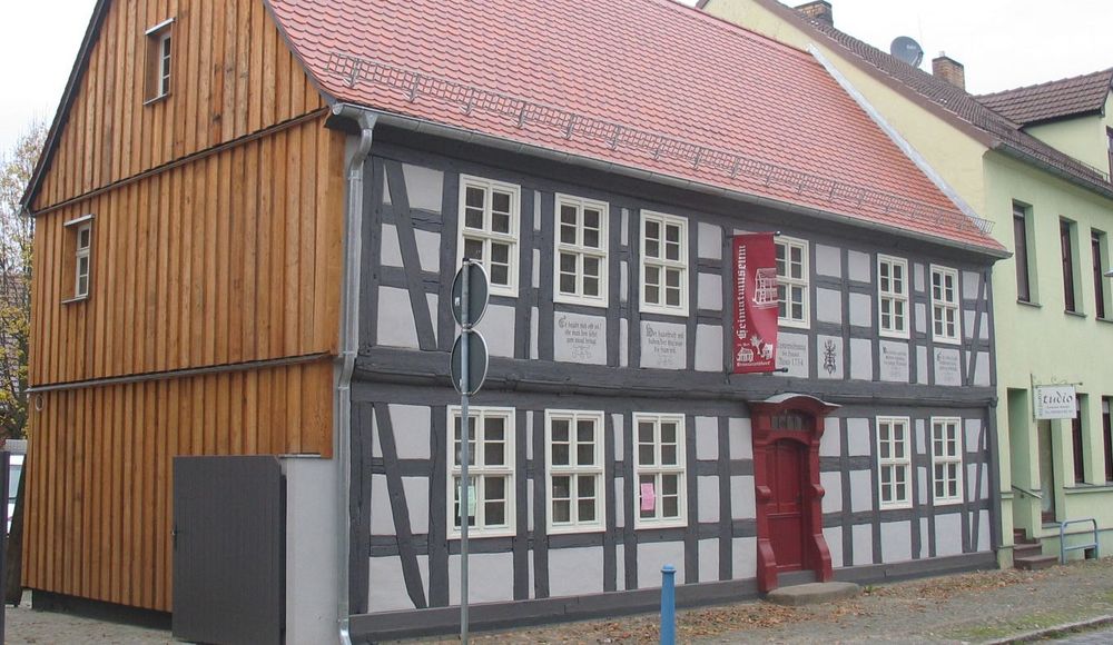 Außenansicht. Blick auf ein altes Fachwerkhaus mit Giebeldach und seitlicher Holzfassade. . 